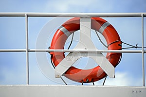 Life belt, life buoy, red rescue ring on a white railing of a cr