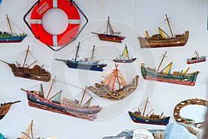 Life belt and models of sailing boats hanging on a wall i