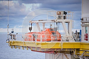 Life boat, survival craft or rescue boat at oil and gas platform for emergency evacuate at muster station photo