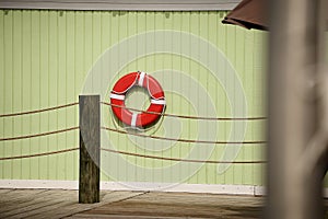 Life buoy hanging on wooden wall