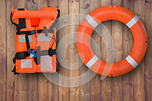 Life buoy and life jacket hanging on wooden wall for emergency response when people sinking to water,sea,pool.