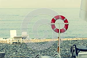 Life buoy on a pole on a beach with blue ocean water
