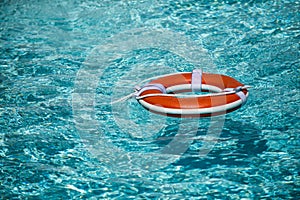 Life buoy for safety at pool in water. Safety equipment, rescue buoy floating to rescue people from drowning.