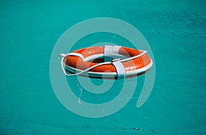 Life buoy for safety at pool in water. Safety equipment, rescue buoy floating to rescue people from drowning.
