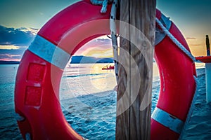 Life buoy by the sea in Alghero shore at sunset