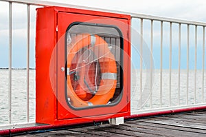 Life buoy in the showcase  hanging on a pontoon  bridge railing  at seashore .