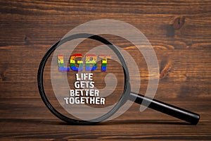 Life gets better together. Quote under a magnyfying glass on wooden background