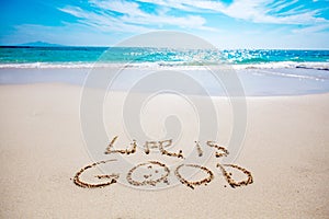 Life is good text on sandy beach