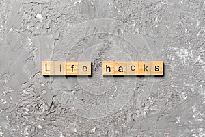 Life hacks word written on wood block. life hacks text on table, concept