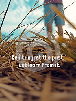 Life inspirational motivational quote - Don\'t regret the past, just learn from it. With dry grass and man feet standing.