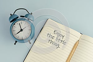 Life inspirational quote - Enjoy the little thing text on note pad with alarm clock