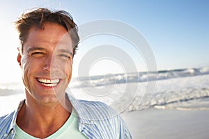 Life is inspiring. Portrait of a handsome man smiling on the beach alongside copyspace.
