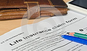 Life insurance claim form on a wooden surface