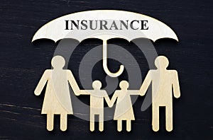 Life insurance concept. Figurines of a family under an umbrella