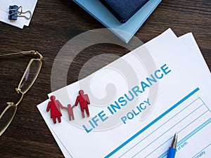 Life insurance policy and figurines of family.