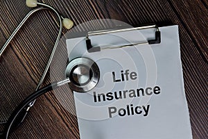 Life Insurance Policy write on a paperwork isolated on wooden table