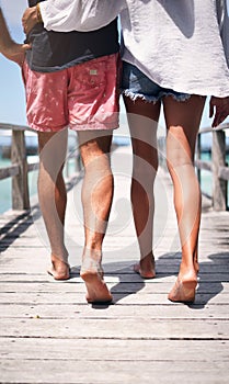 In life, its not where but who we travel with. Rearview shot of an unrecognizable couple walking arm in arm along the