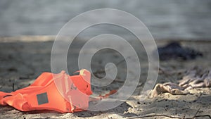 Life jacket lying on seashore, disaster area, catastrophe mortality statistics