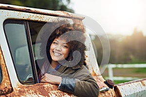 Life is a journey. Portrait of a happy young woman sitting in a rusty old truck.