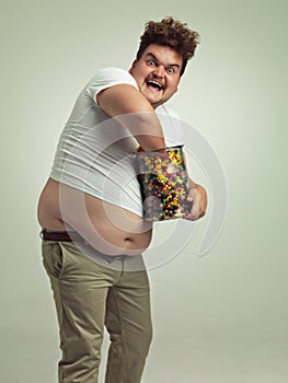 Life is like a pot of candy - you never know what youre gonna get next. an overweight man reaching into a jar of candy.