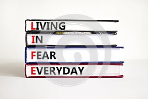 LIFE living in fear everyday symbol. Concept words LIFE living in fear everyday on books on a beautiful white table white