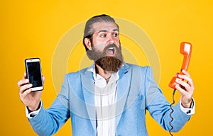 life meets possibilities. mature bearded man with retro phone. male hold smartphone. compare technology. mobile phone vs