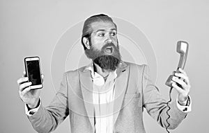 life meets possibilities. mature bearded man with retro phone. male hold smartphone. compare technology. mobile phone vs