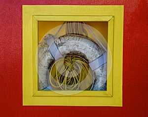 Life preserver and rope hanging in box on dock