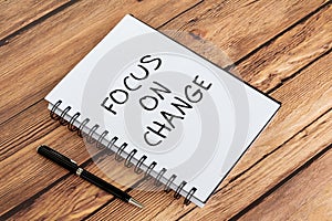 Life quotes on note pad - Focus on change. Wood background