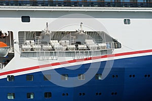 Life rafts arranged in forward part of the cruiser passenger vessel with white and blue hull.