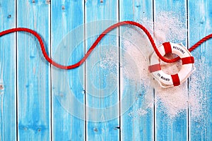 Life Ring with Red Rope on Blue Wood Background