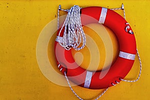 Life saver buoy hanging in a yellow wall photo