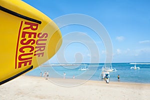 Life saving yellow board with surf rescue sign on beach