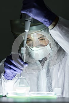 Life scientist researching in bio hazard laboratory. High degree of protection work.