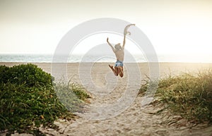 Life is short, spend it at the beach. Rearview shot of a happy young woman enjoying a day at the beach.