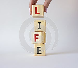 Life symbol. Concept word Life on wooden cubes. Businessman hand. Beautiful white background. Business and Life concept. Copy