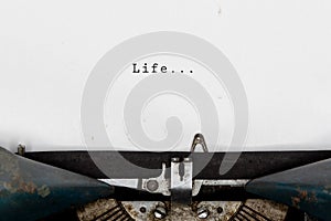 Life typewriting on an old vintage typewriter, retro machine with white sheet of paper. Start your life story concept. photo