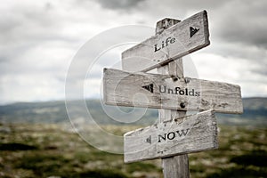 Life unfolds now signpost outdoors
