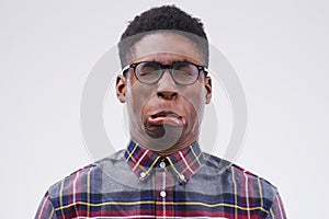 Because life would be boring without a bit of fun. Studio shot of a young man making a funny face against a gray