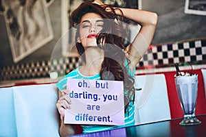 Life wouldnt be fun if we were all the same. Cropped portrait of an attractive young woman holding up a sign while