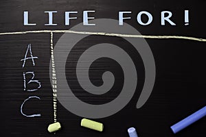 Life For! written with color chalk. Supported by an additional services. Blackboard concept