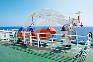 Lifeboat and crane aboard a ferry or cruise ship at sea. Transport and travel concept