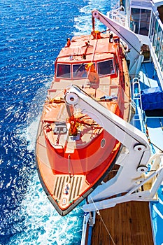 Lifeboat of cruise ship in bright blue waters of Piraeus port Greece