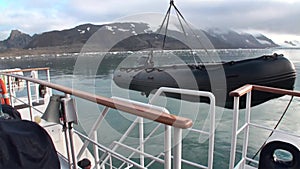 Lifeboat lowered into the water from ship in Svalbard.