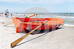 lifeboat on the sandy beach - unrecognizable people in the background