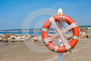 Lifebuoy on empty beach in summer day