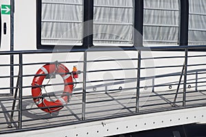 Lifebuoy and handrails on the gangway to the ship at the pier.