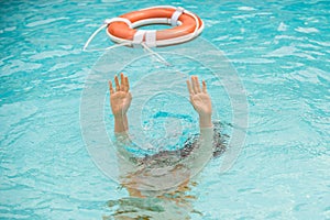 Lifebuoy with hands in the water. Life buoy and helping to survive. Drown people with rised hand getting lifebuoy help photo