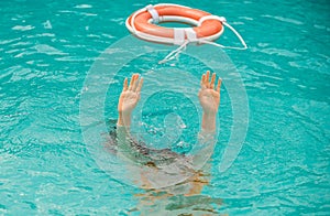 Lifebuoy with hands in the water. Life buoy and helping to survive. Drown people with rised hand getting lifebuoy help photo