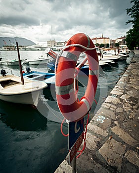 Lifebuoy hanging in sea port at rainy day
